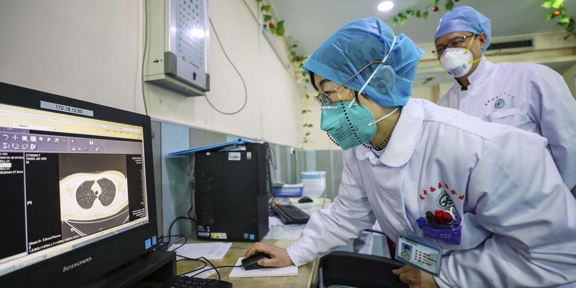 Läkare undersöker en patients lungor på ett sjukhus i Wuhan, Kina.