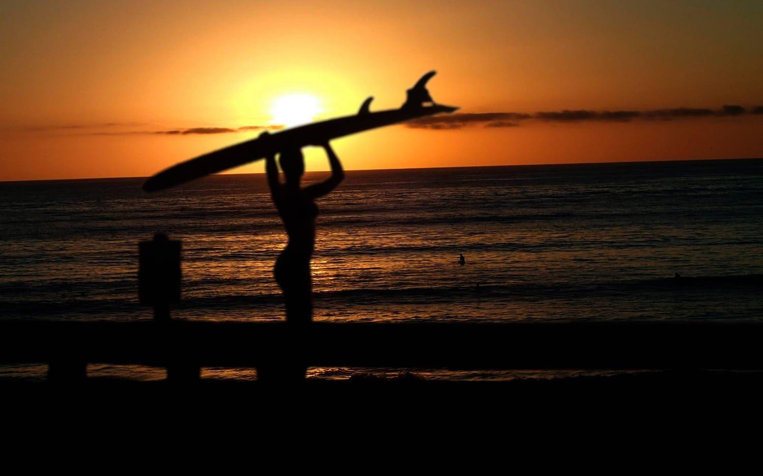 Annelie Pompe med surfbrädan och en magisk solnedgång i Indonesien. Bild: Privat