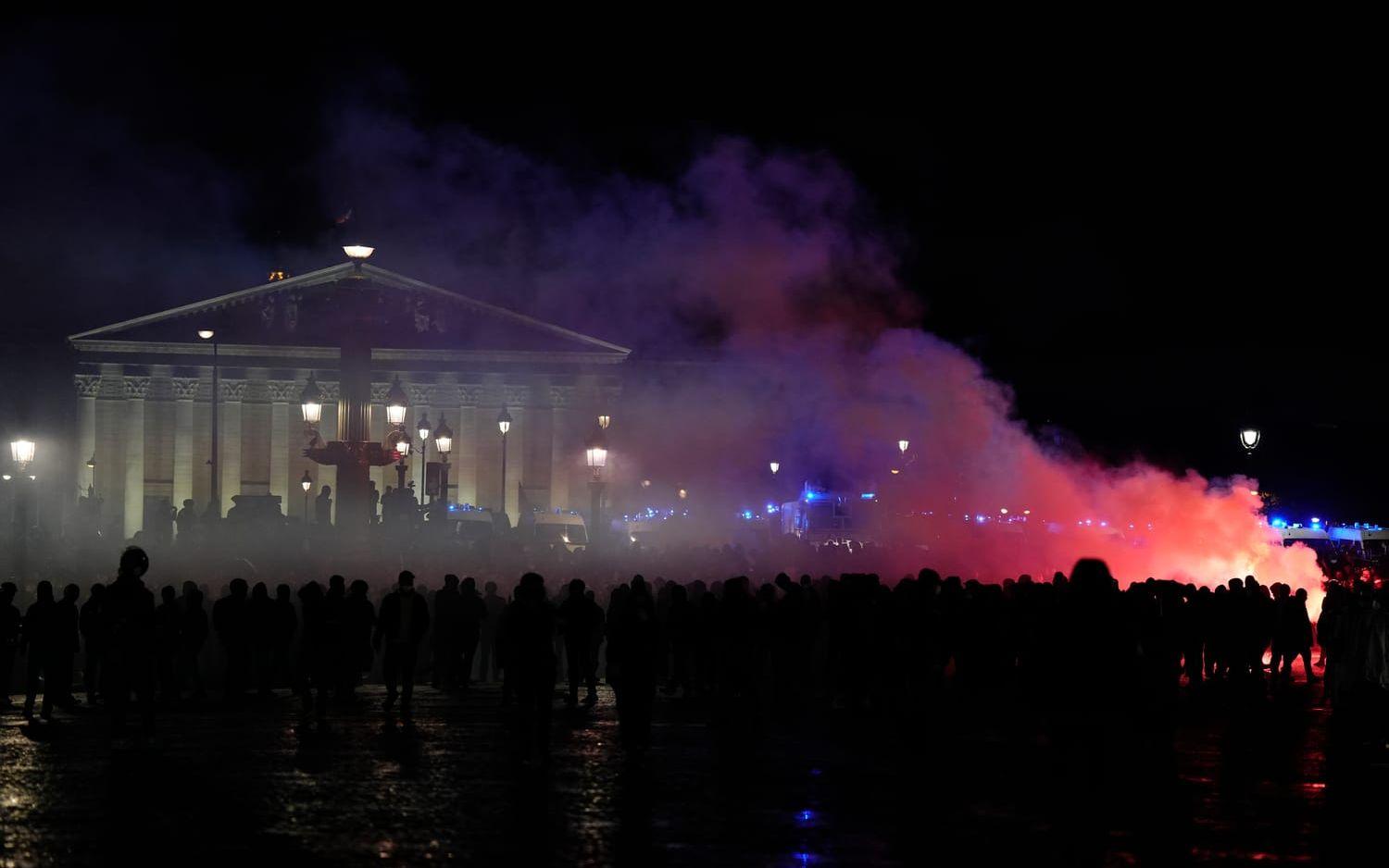Demonstranter som under fredagskvällen samlats framför parlamentsbyggnaden i Paris.