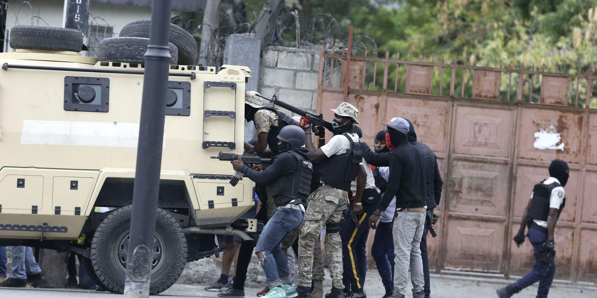 Poliser tar skydd bakom ett förstärkt fordon under skottväxling med arméns soldater, mitt i Port-au-Prince.