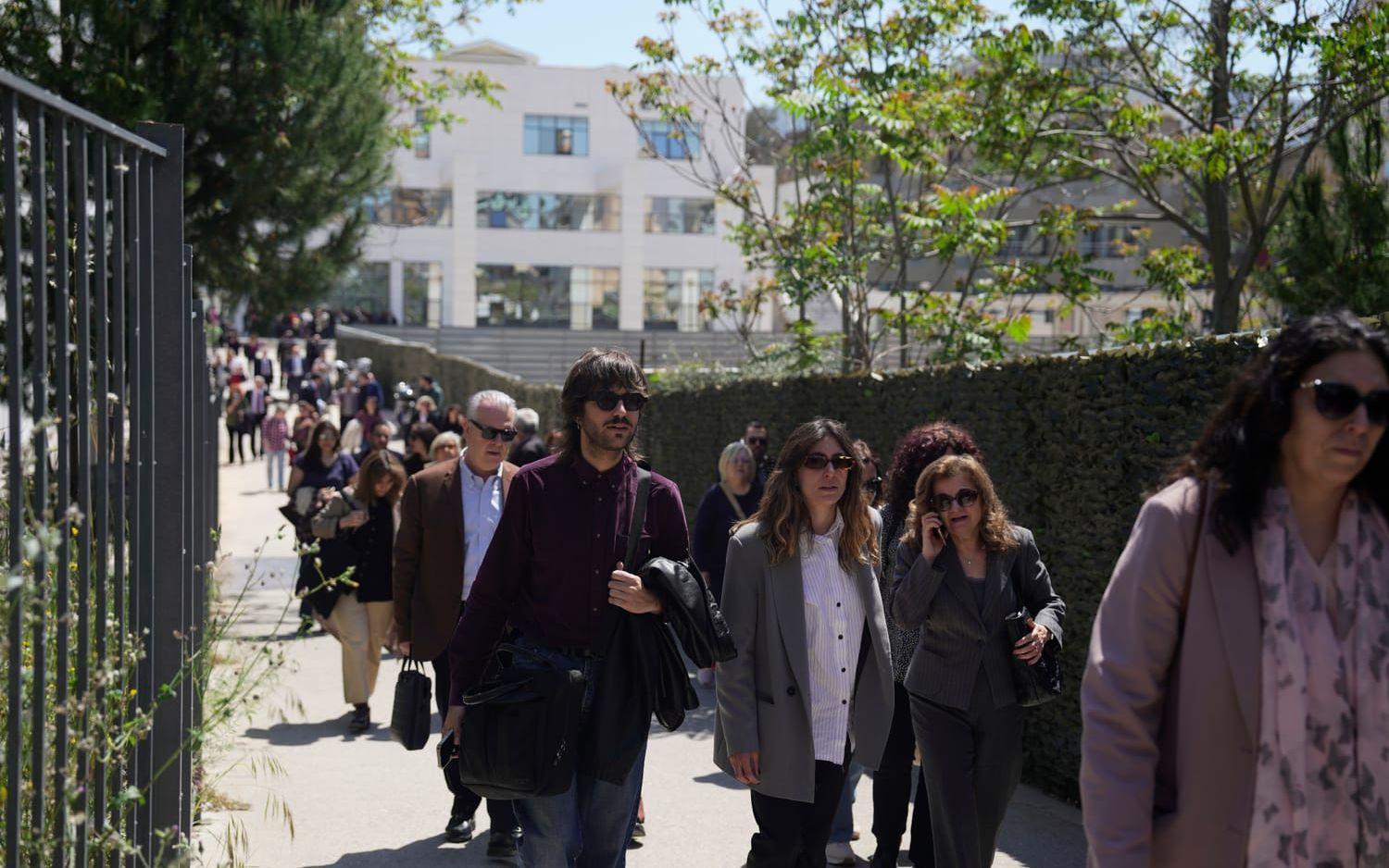 Människor lämnar en domstol i Aten sedan en man öppnat eld på platsen.