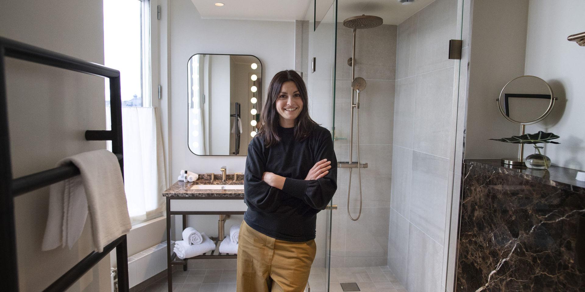 Noemi Ivanova i ett av badrummen på nya Bank Hotel som hon har hjälpt till att inreda. Där är duschhörnan kaklad, men inte övriga badrummet – en tydlig trend just nu. Diskreta plattor i storformat och närmast osynliga fogar är också hett.