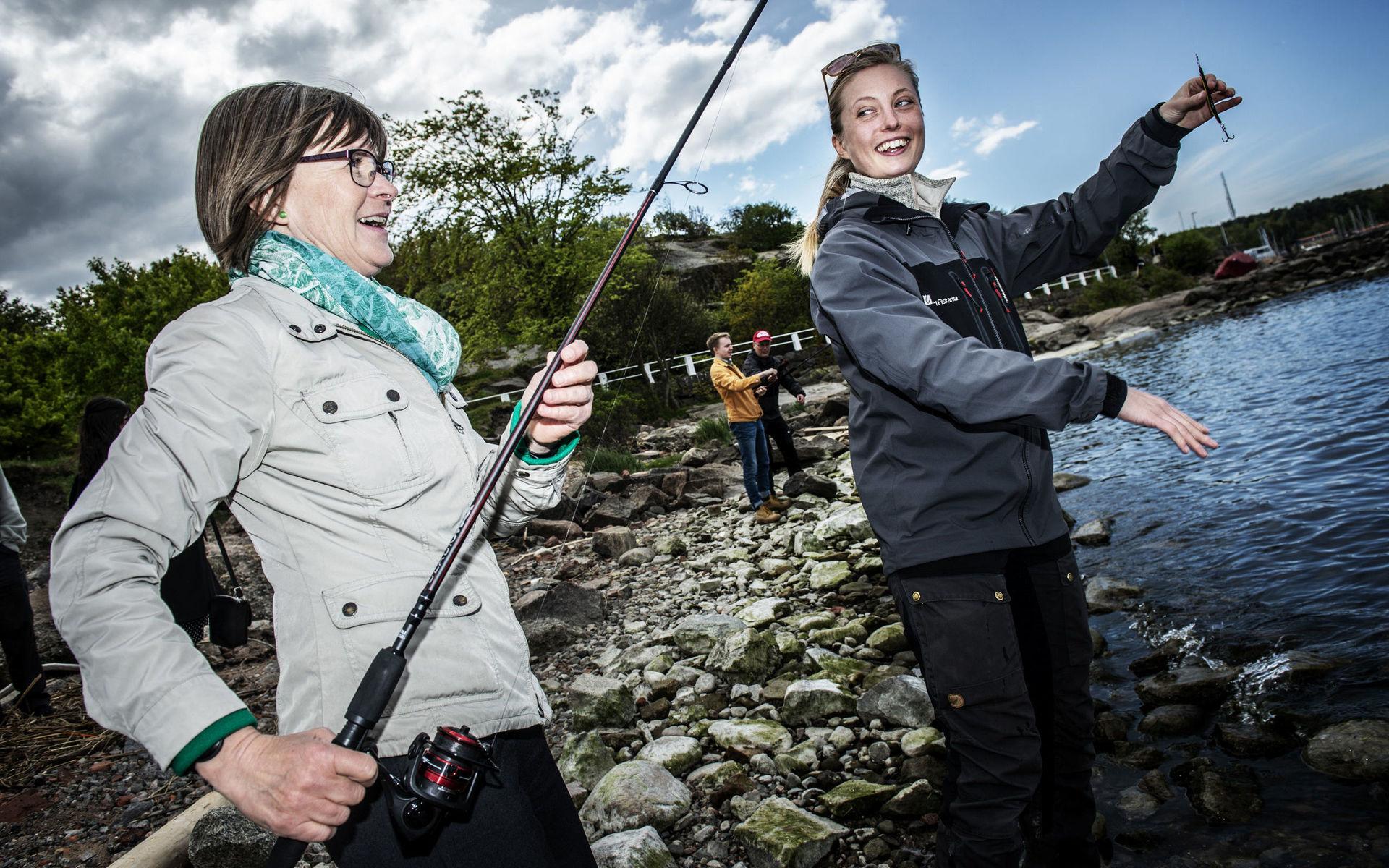 Karin Pleijel testar fiskelyckan. Matilda Lundh Åkervall ger en hjälpande hand.