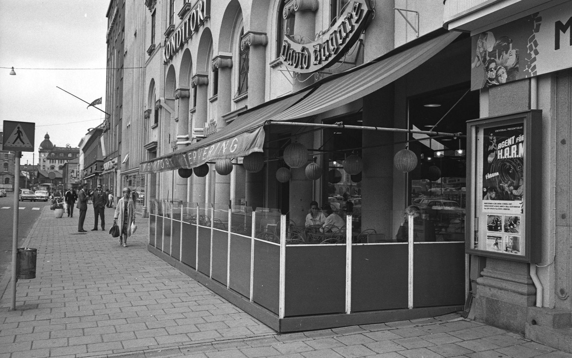 1965-08-05. Bilden visar Konditori David Bagare på Järntorgsgatan. Till höger ser vi också att biografen Rialto visar &quot;spy-fi&quot;-rullen Agent för H.A.R.M