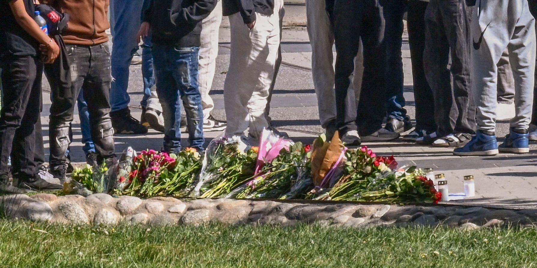 Sörjande och blommor på platsen i Hammarby sjöstad i Stockholm där en 15-årig pojke höggs till döds under fredagskvällen.