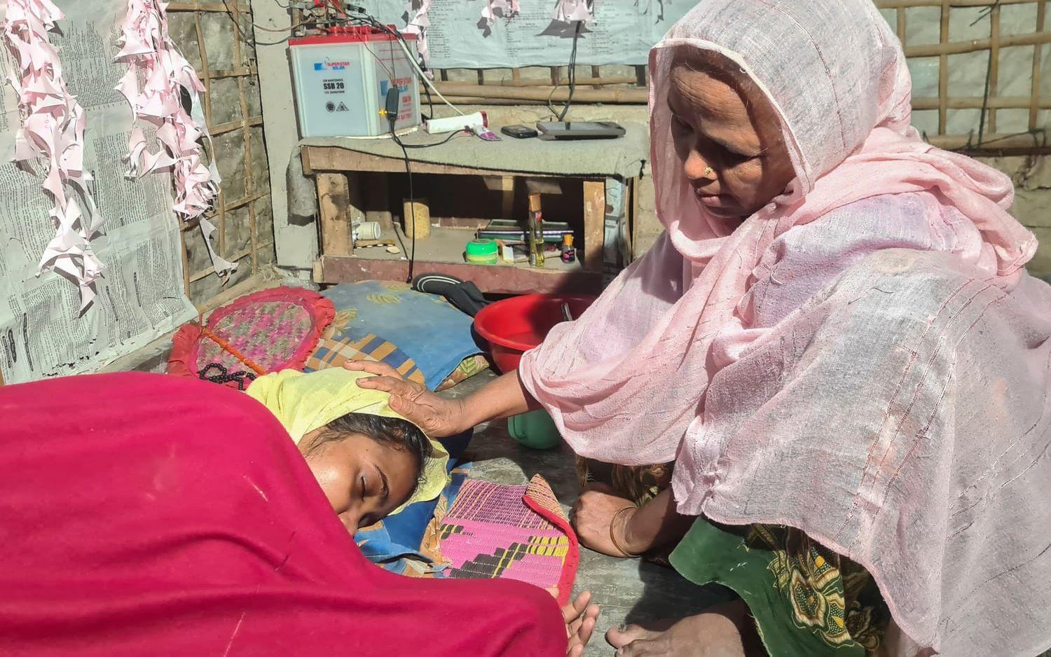 Majuma Khatun tröstar sin dotter Rahela Begum, som räddats från en kapsejsad båt med rohingyer på flykt, i Cox's Bazar i Bangladesh i april.
