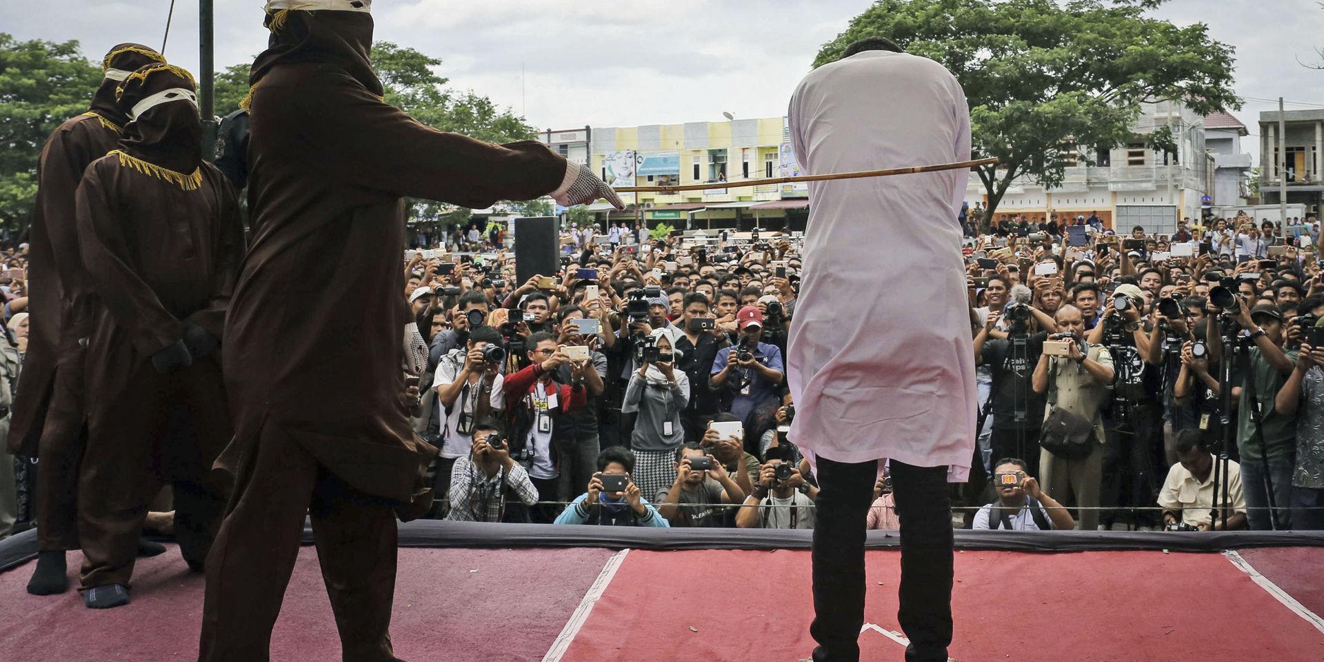 En man som dömts för att ha haft sex med en annan man pryglas under en offentlig piskning i Banda Aceh. Bilden är från i maj 2017. 