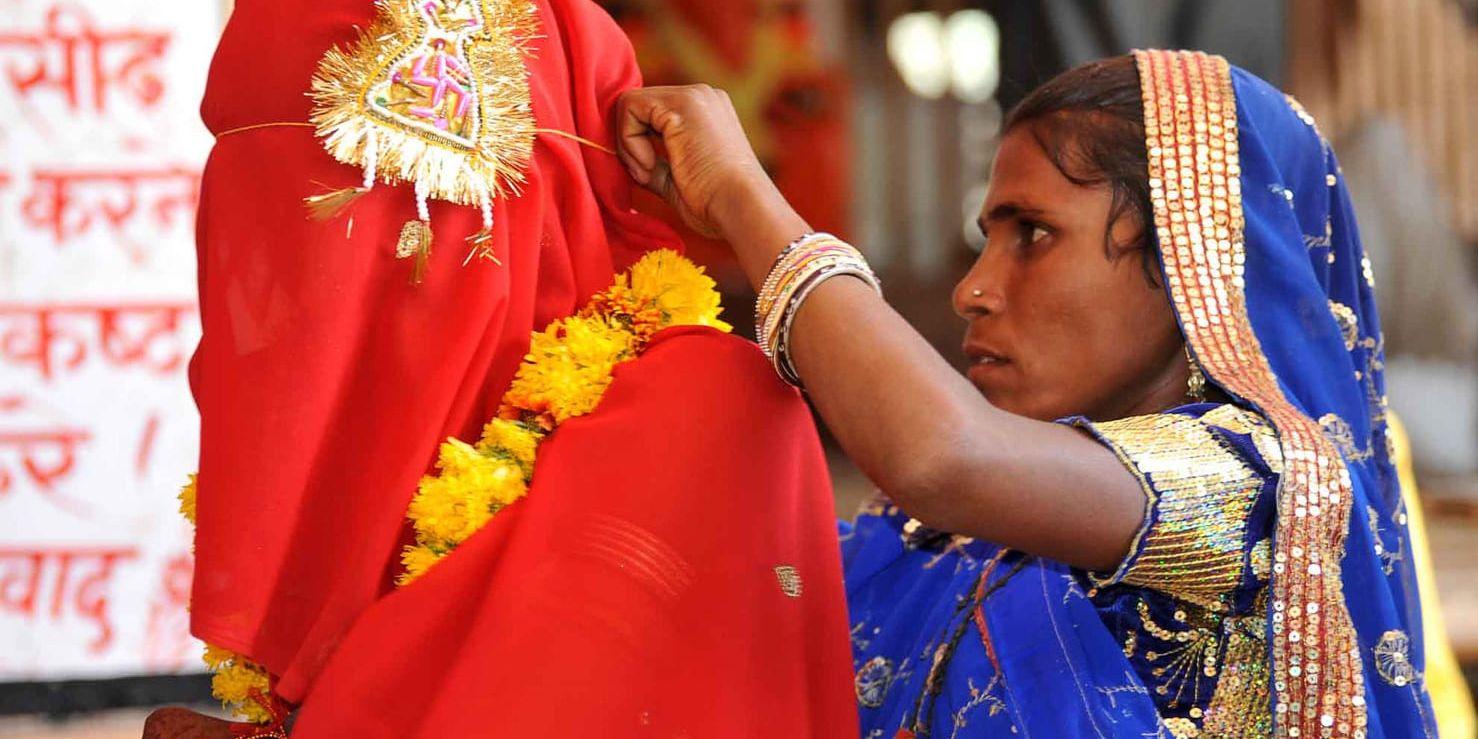 En kvinna rättar till slöjan för en 15-årig flicka som är på väg att giftas bort i den indiska delstaten Rajastan. Arkivbild.