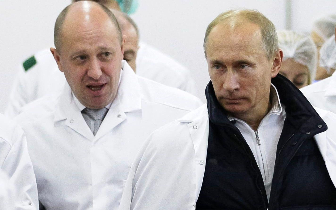 Jevgenij Prigozjins krögarkonglomerat tilldelades statliga upphandlingar värda miljardbelopp. Här träffades han och Vladimir Putin på en skolmatsfabrik i S:t Petersburg 2010. Arkivbild.