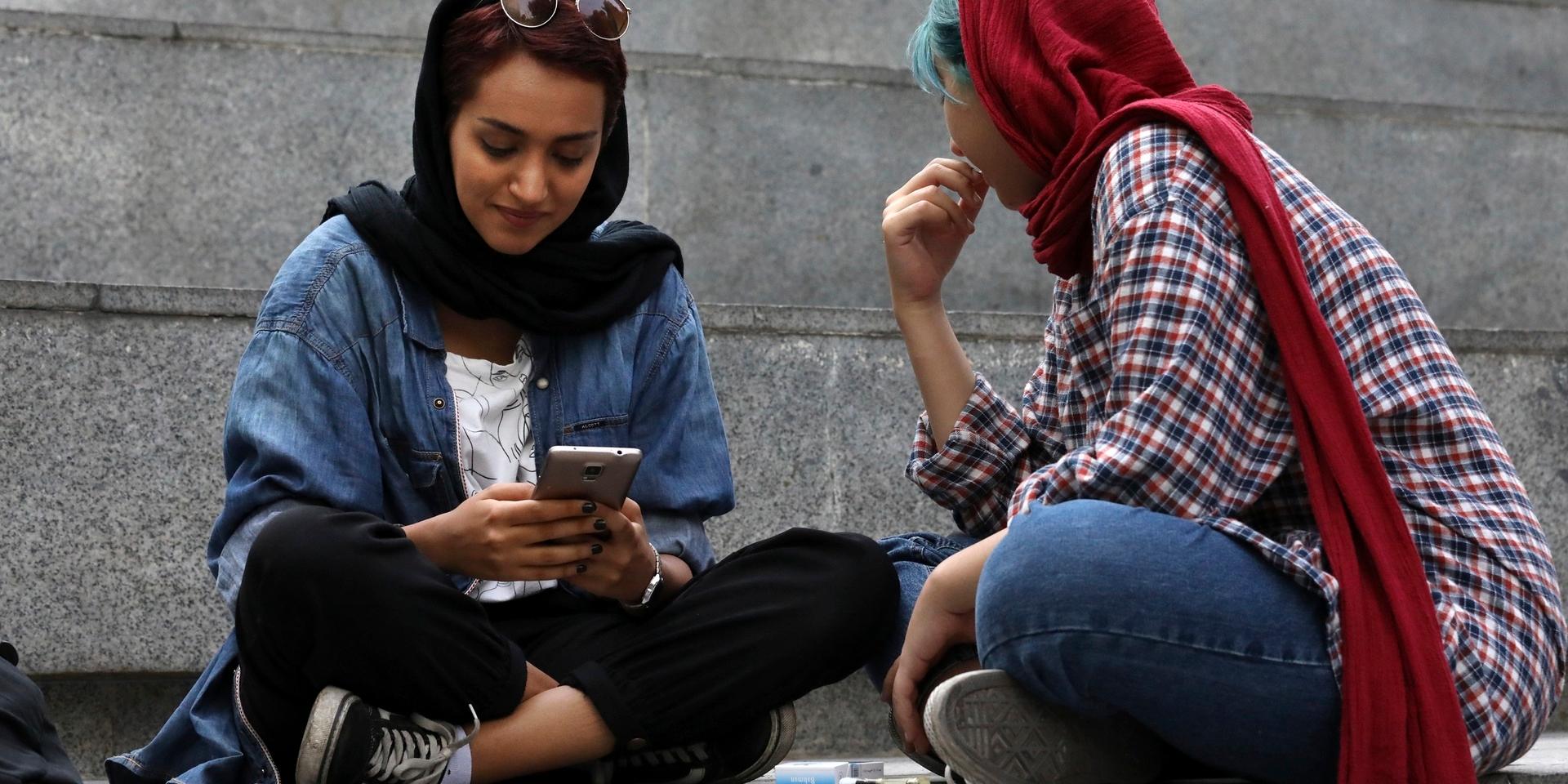 En ung kvinna kollar sin mobil i Teheran. Står kärleken att finna i flödet? Arkivbild.