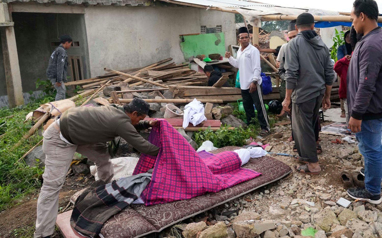 Familjemedlemmar gör i ordning kroppen efter ett ungt offer för jordbävningen som förstörde tusentals byggnader och dödade minst 252 personer.
