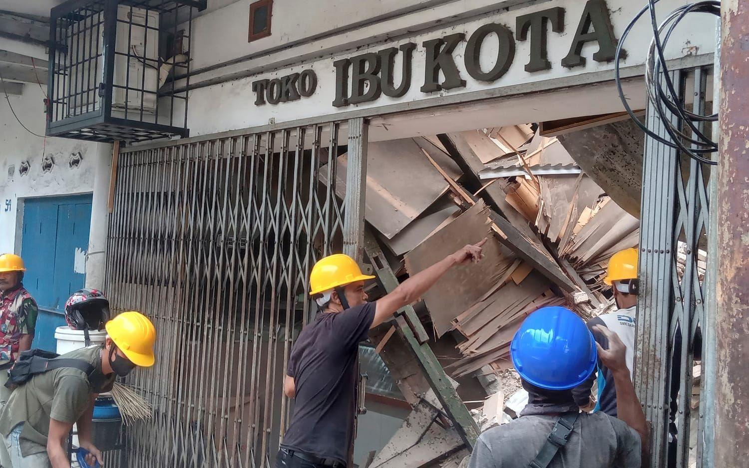 Räddningsarbetare ser över de stora skadorna i en affär i Cianjur. Skalvets epicentrum var vid staden.