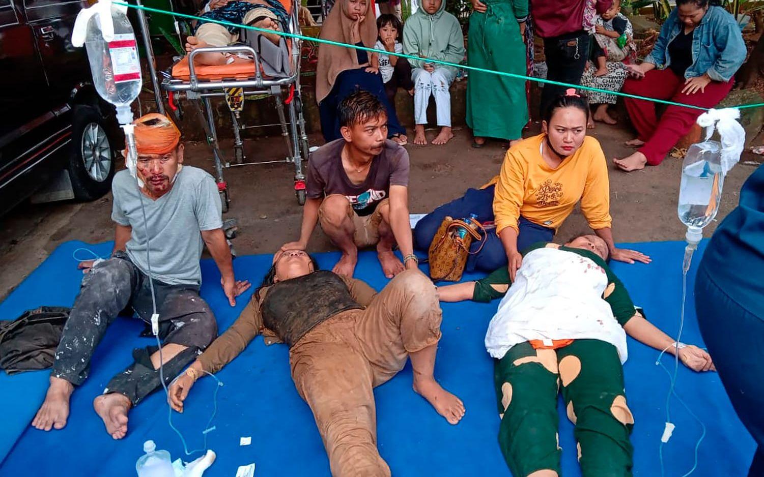 Skadade människor får vård på en parkeringsplats utanför sjukhuset i Cianjur på västra Java.