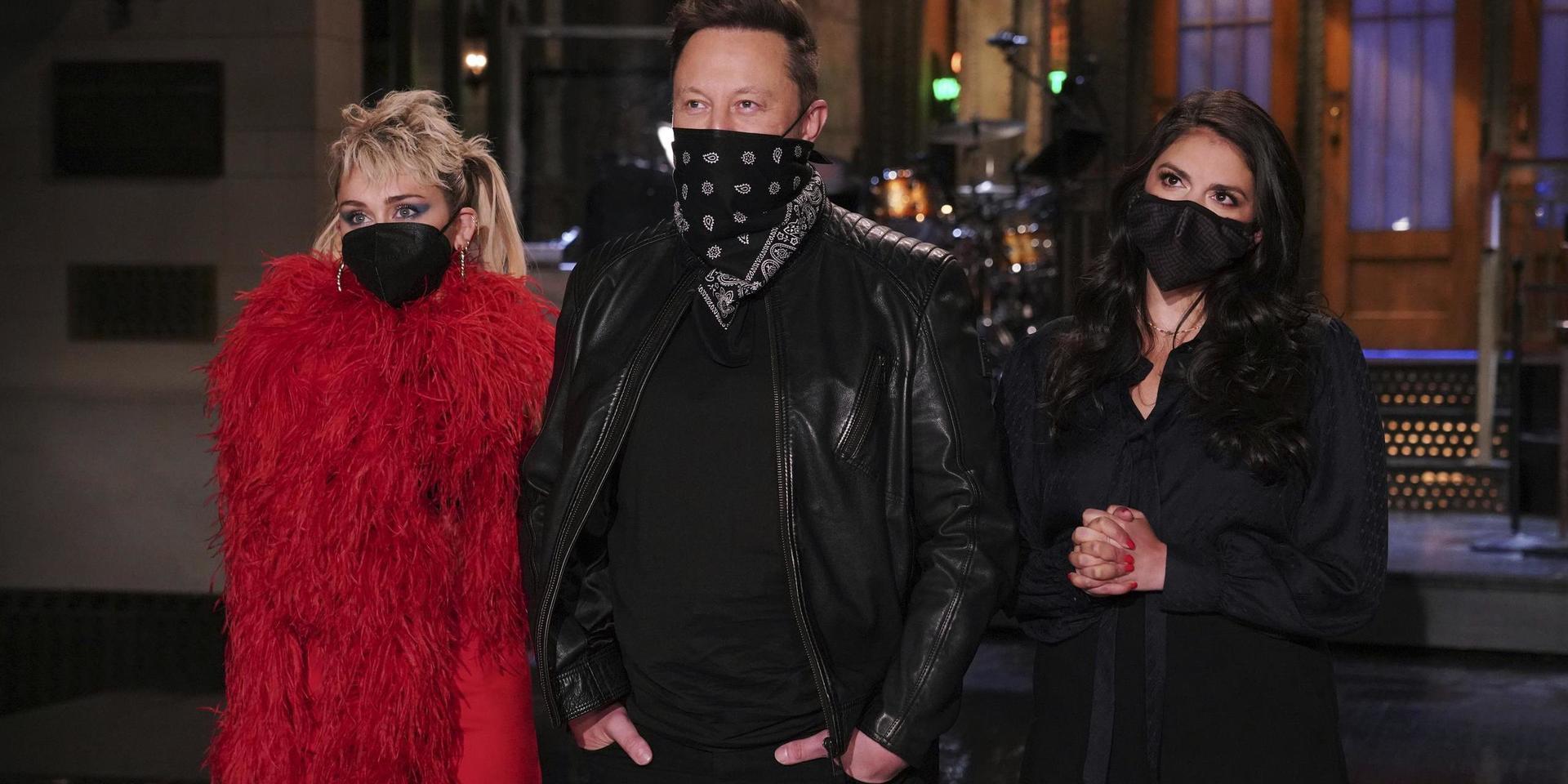 Elon Musk poserar med artisten Miley Cyrus (vänster) och komikern Cecily Strong (höger) inför helgens 'Saturday Night Live'.