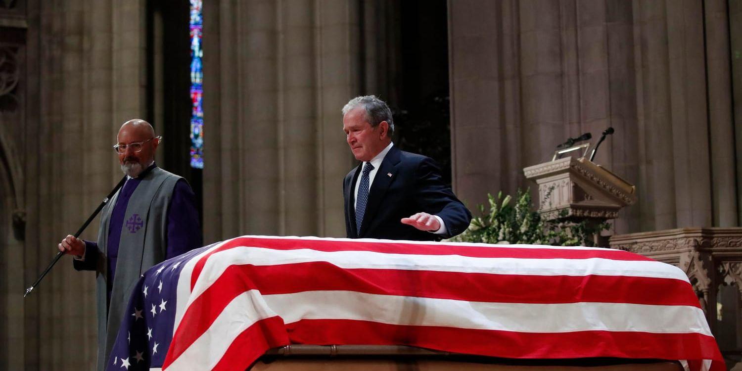 George W Bush klappade sin fars kista lätt efter ett tal under statsbegravningen i Washington på onsdagen.