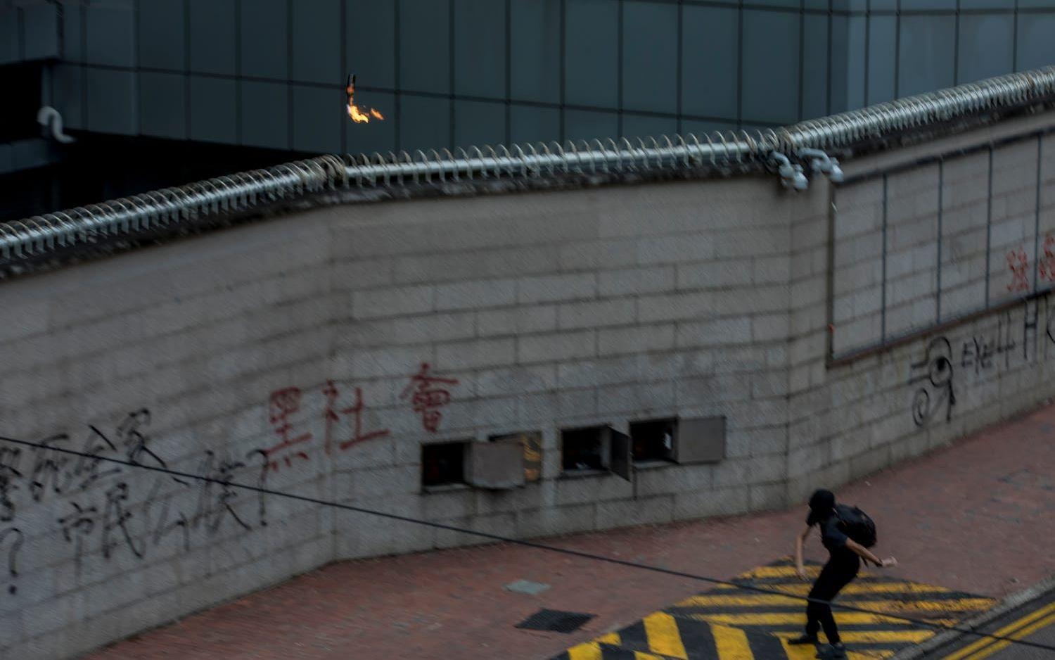 En maskerad man kastar en bensinbomb mot regeringens högkvarter.