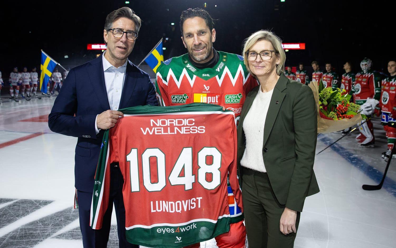 Frölundas klubbdirektör Christian Lechtaler och SHL:s VD Jenny Silfverstrand uppvaktar Joel Lundqvist efter att han spelat flest SHL matcher genom tiderna.