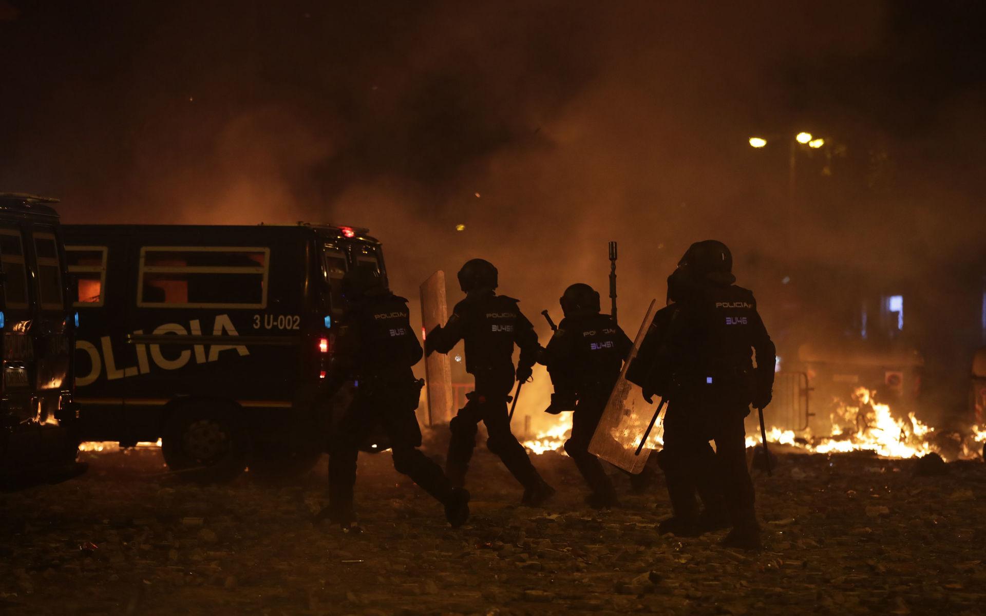 Polis framför brinnande barrikader nära Placa de Catalunya.