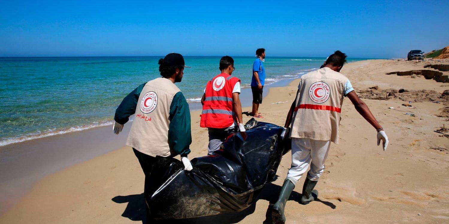 Libyska Röda Halvmånen bärgar kroppar efter migranter på stranden vid Castelverde utanför Tripoli.