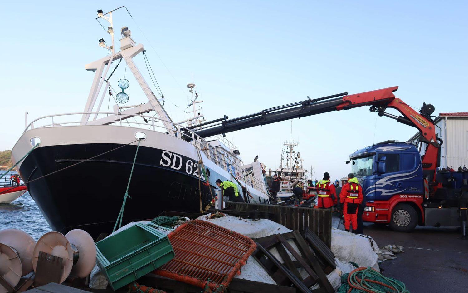 En kranbil kördes till hamnen för att lyfta upp fiskebåten under räddningsarbetet. 