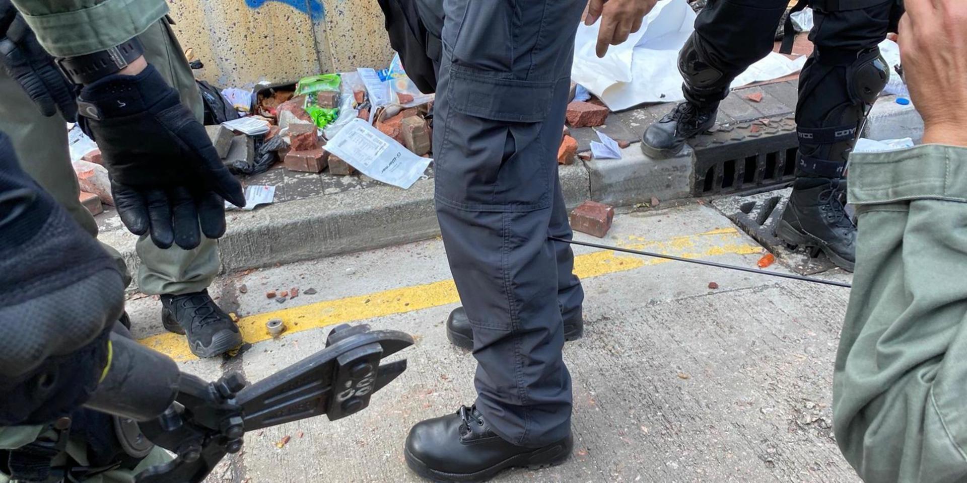 I en bild som släppts från polismyndigheten i Hongkong förbereder sig polisen för att ta bort en pil som träffat en polisanställd.