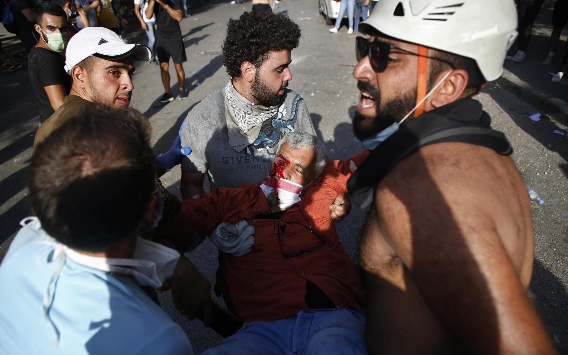 En skadad tas om hand av demonstranter.