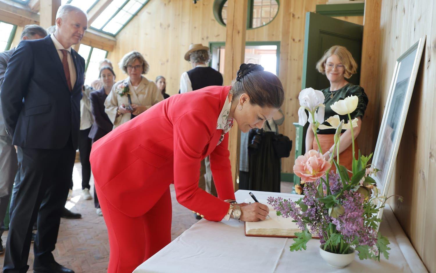 Kronprinsessan Victoria skriver i gästboken, i sällskap med landshövding Sten Tolgfors (tv) och intendent Johanna Lindén, då hon besöker Gunnebo Slott och Trädgårdar under sitt besök i Göteborgsområdet.