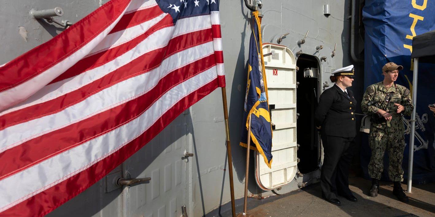 Löjtnant Elizabeth Armstrong och Malachi Lakey, underofficer och fotograf, hälsar välkomna på robotkryssaren USS Normandy.