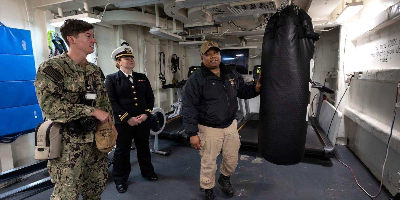 Malachi Lakey, Elizabeth Armstrong och Anthony Bryant ingår i besättningen på robotkryssaren USS Normandy. Här står de i ett av fartygets gym som rymmer allt från hantlar till löparband.