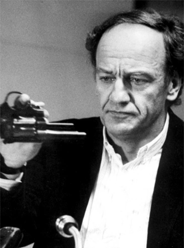 Länspolismästaren och spaningsledaren Hans Holmér visar upp en revolver på en presskonferens i mars 1986.