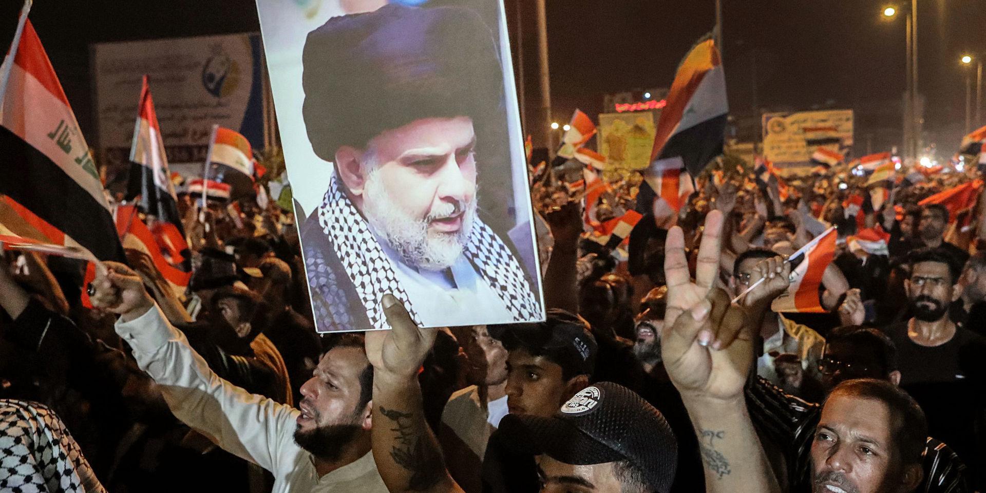 Demonstranter visar en bild på den shiitiske ledaren Muqtada al-Sadr under de pågående protesterna i Irak. Nu har al-Sadr själv förenat sig med demonstranterna i Najaf.