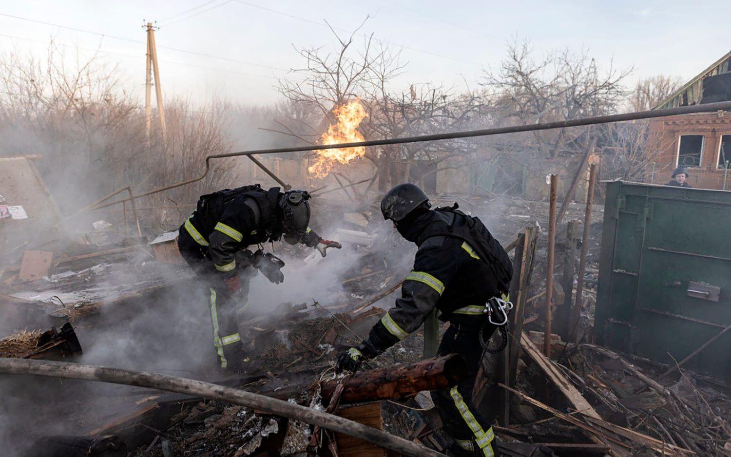 Ukrainska brandmän släcker efter ryska attacker mot ett samhälle i Donetsk.