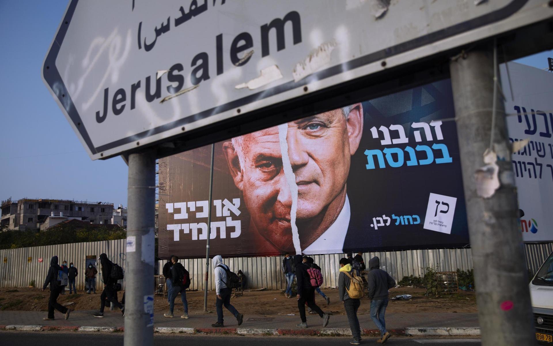 Palestinier går förbi en valaffisch från Benny Gantz parti Blåvitt. Valet har kommit att handla om en sak: Ja eller nej till Netanyahu.