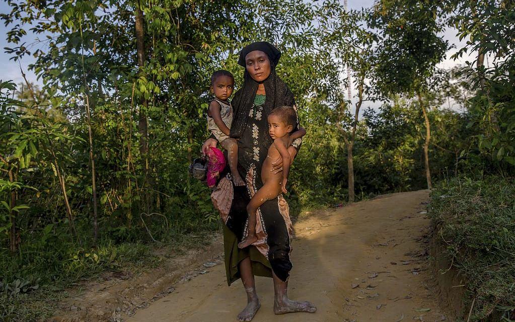 Zahida Banoo håller sina två barn på väg till flyktinglägret Kutupalong. Bild: Dar Yasin