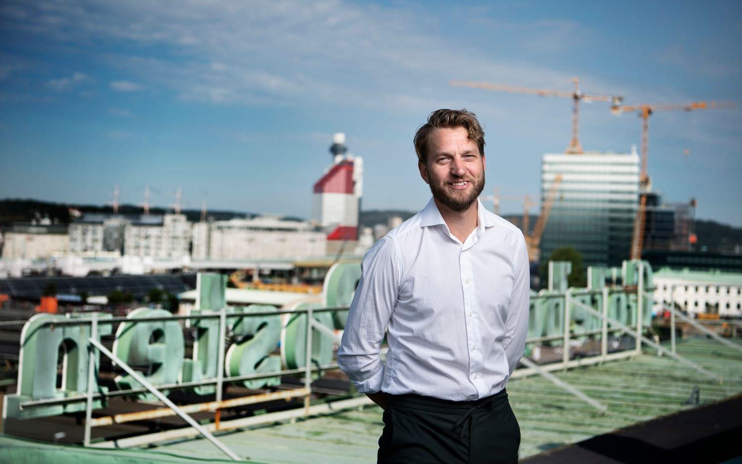 Leende man i vit skjorta på tak, i bakgrunden Göteborgs-Posten skylten. 