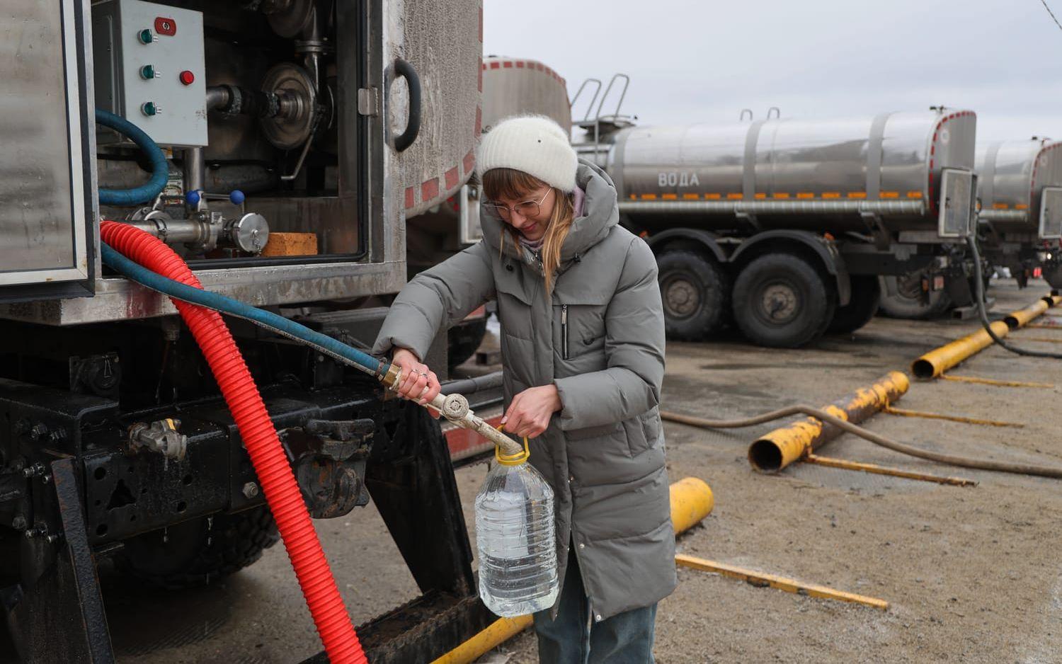 En kvinna häller upp vatten som distribueras av de Rysslandslojala myndigheterna i staden Donetsk i östra Ukraina. Bilden togs förra veckan.