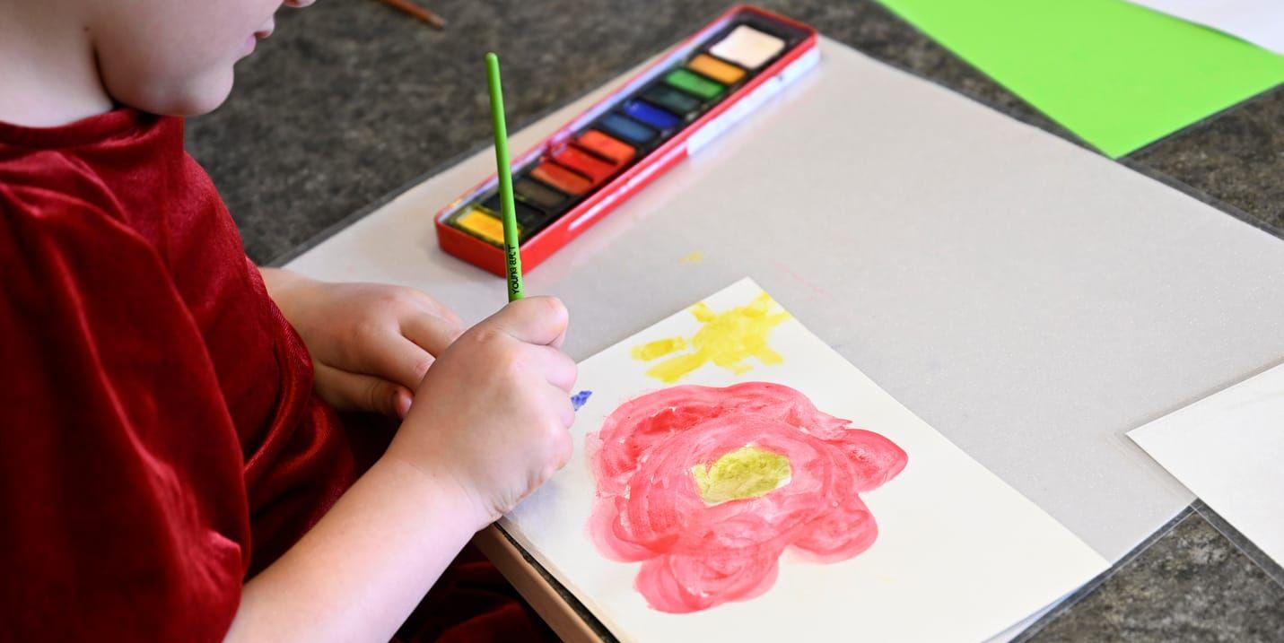 Bilden visar ett barn som målar på en förskola. 
