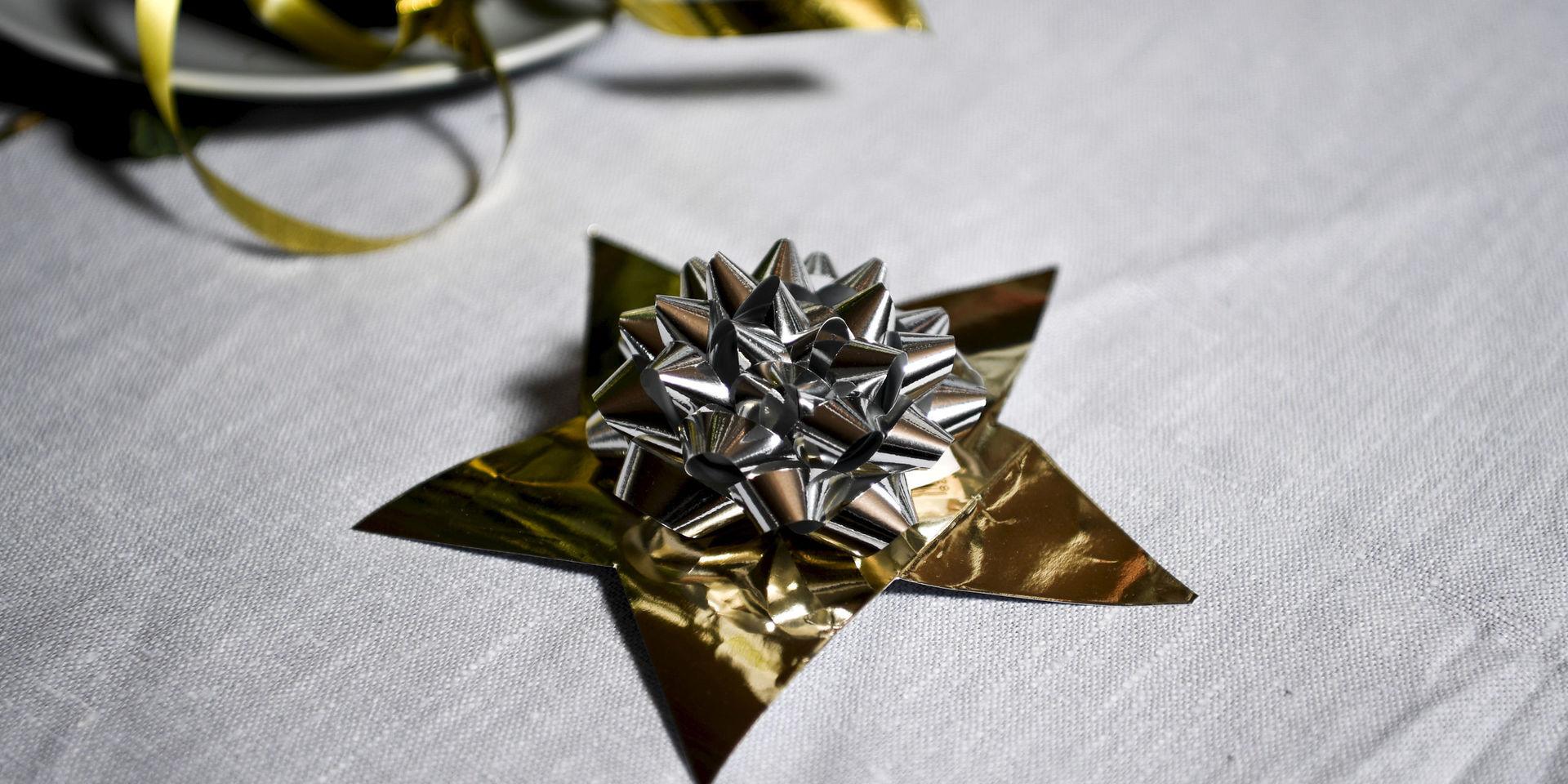 Guld och silver passar på nyårsafton. Presentkartongen från julafton har förvandlats till en stjärna och paketrosen återanvänds som dekoration.