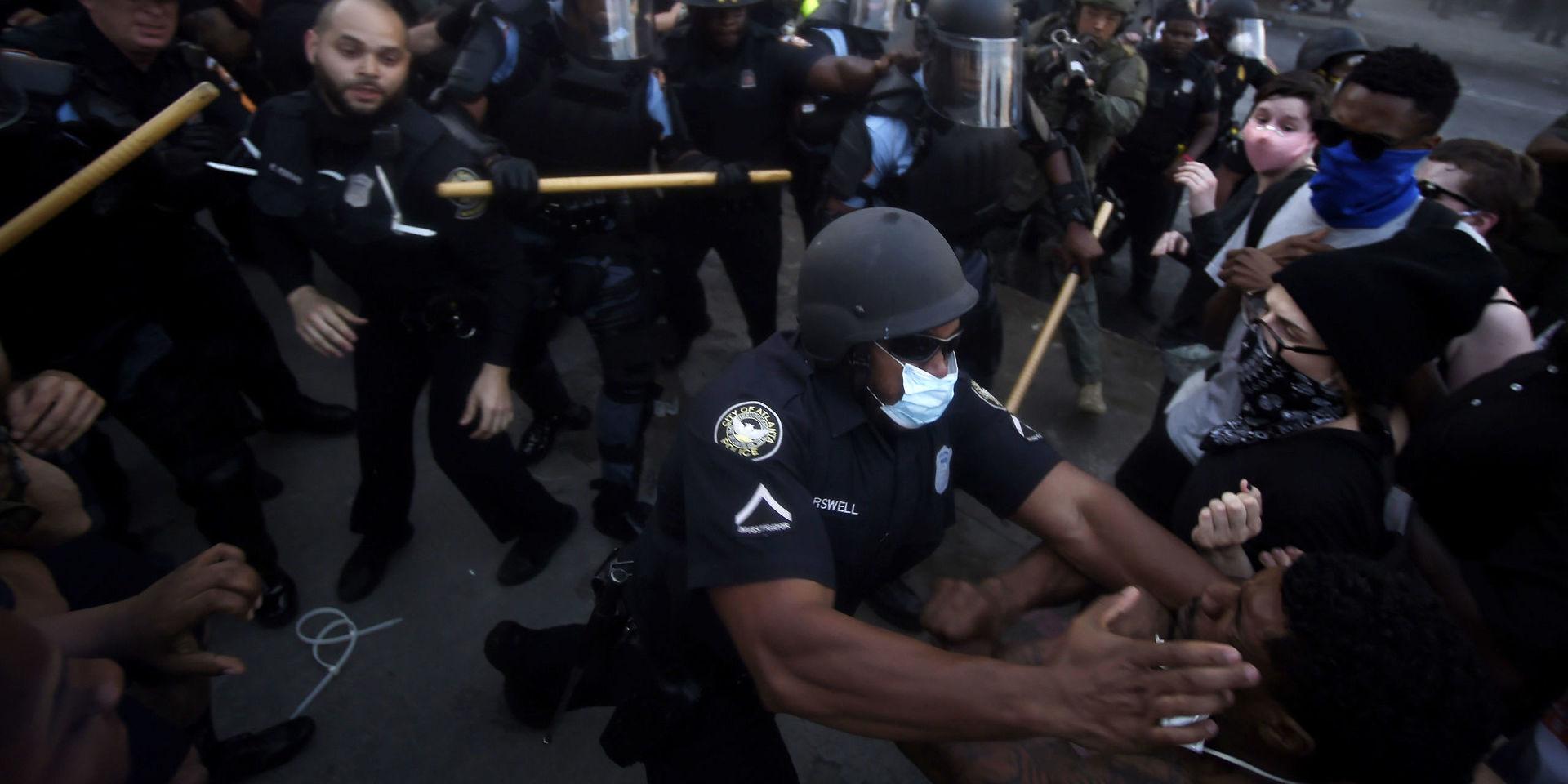 Poliser drabbade samman med protestanter utanför CNN:s huvudkontor i Atlanta på fredagen.