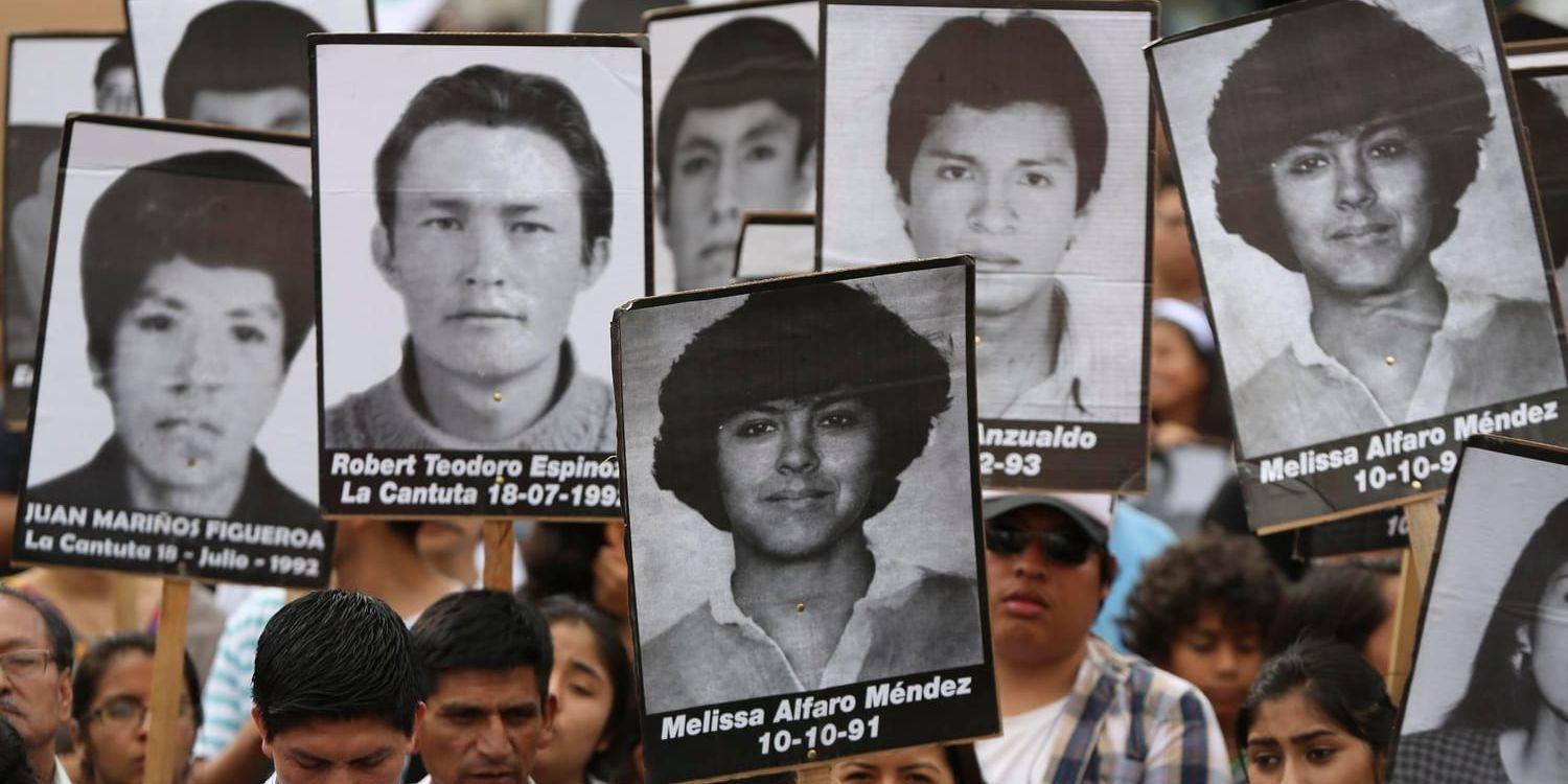 Demonstranter håller upp bilder på människor som försvann under Alberto Fujimoris styre vid en protest i måndags mot benådningen av honom.