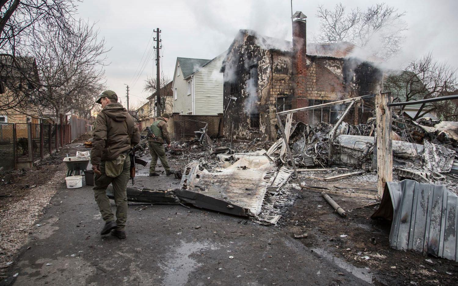 Ukrainsk militär går genom spillrorna av ett flygplan som av oklar anledning kraschat på gatan.