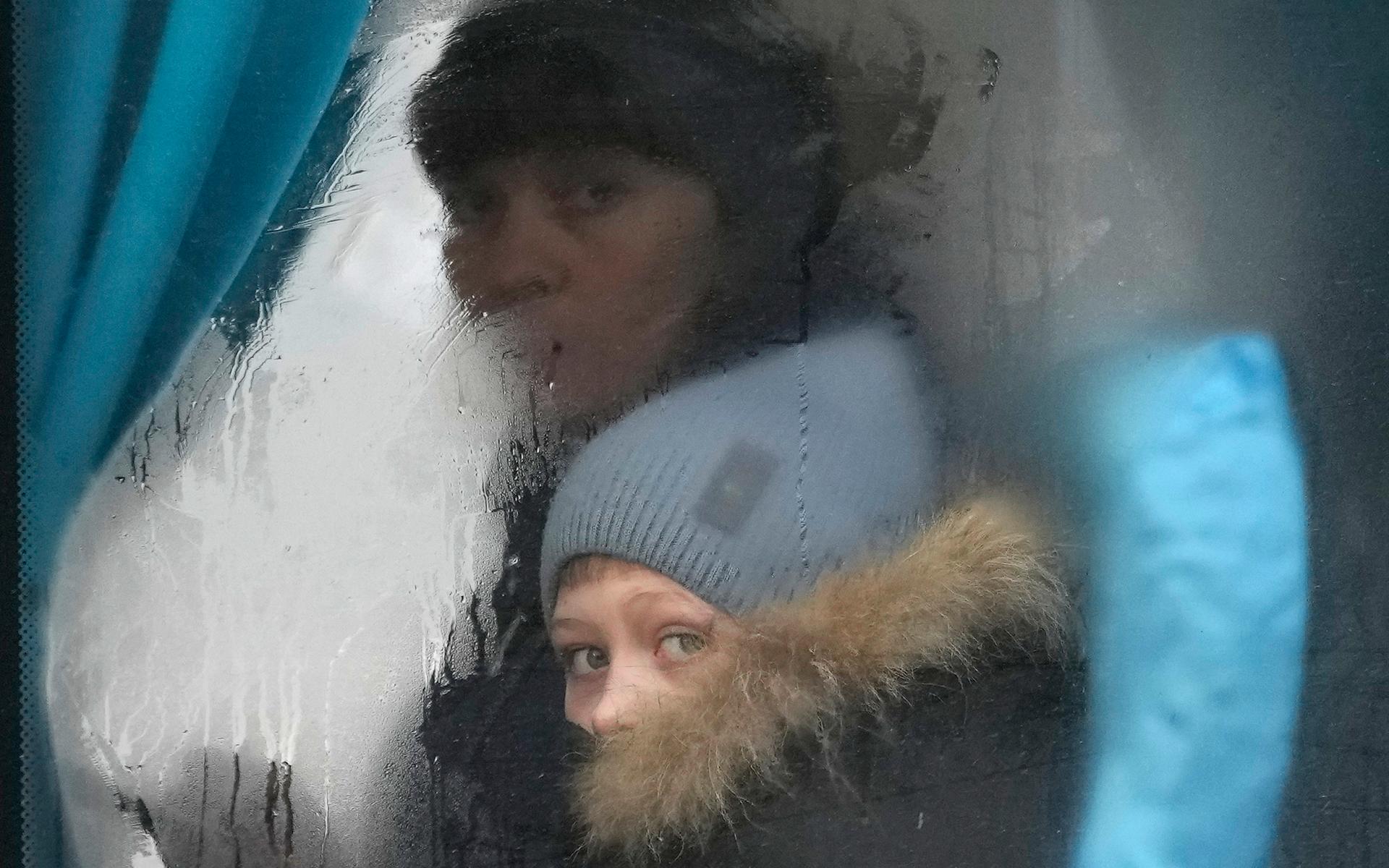 En kvinna och ett barn på en buss på väg ut ur Sievierodonetsk i regionen Luhansk.