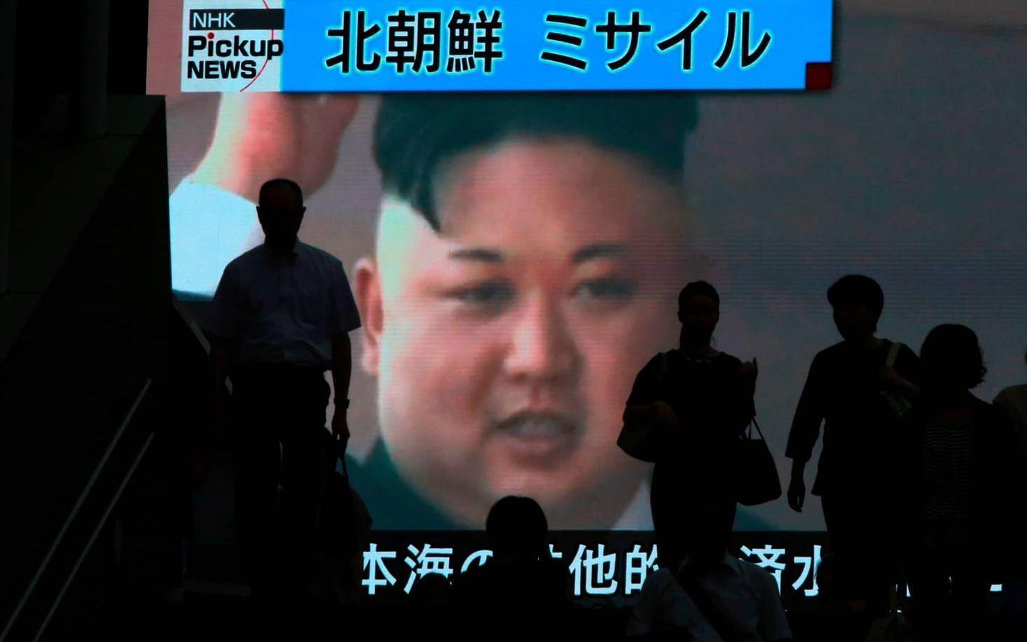 Människor passerar en storbildskärm i Nordkorea, som visar nyheten om missiltestet. Bild: AP Photo/Eugene Hoshiko/TT