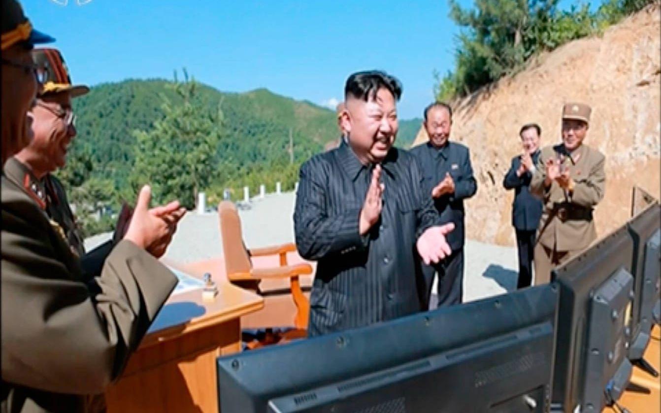 Nordkoreas ledare Kim Jong-Un, omgiven av militära ledare, firar det lyckade missiltestet. Bild: KRT/AP/TT