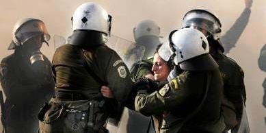 En kvinna grips av polis i Aten på upploppens fjärde dag.