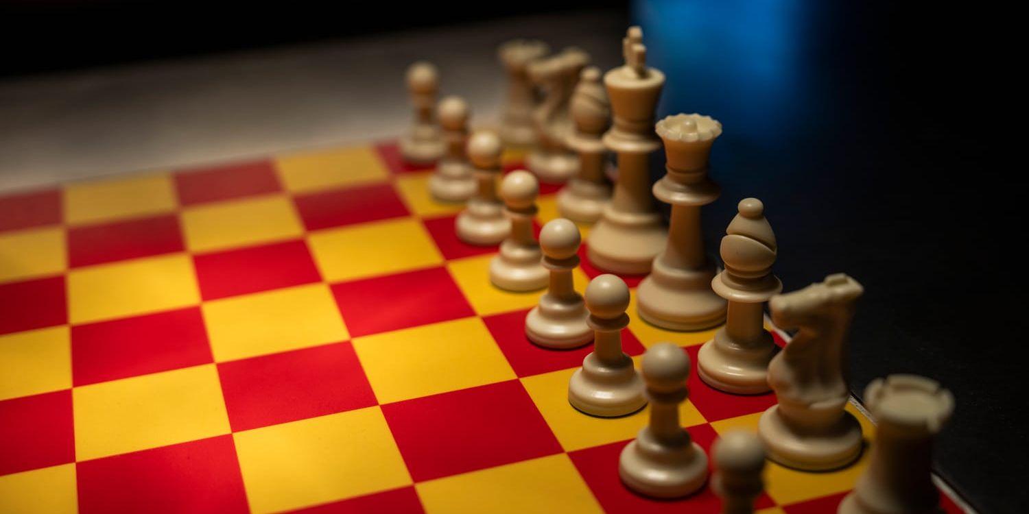 Ett gul- och rödrutigt schackbräde med vita pjäser.