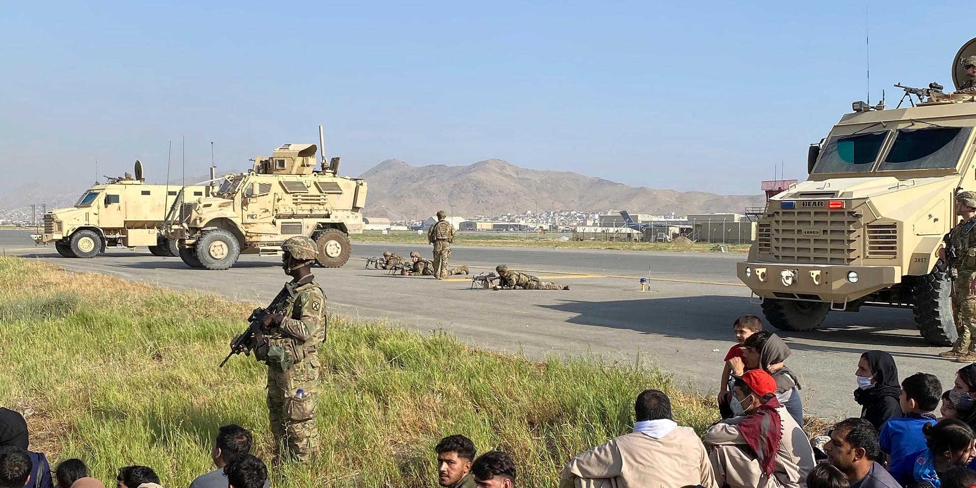 Amerikanska soldater vaktar den internationella flygplatsen i Kabul, där desperata afghaner försökte ta sig ombord på planen som lämnade landet efter talibanernas maktövertagande.