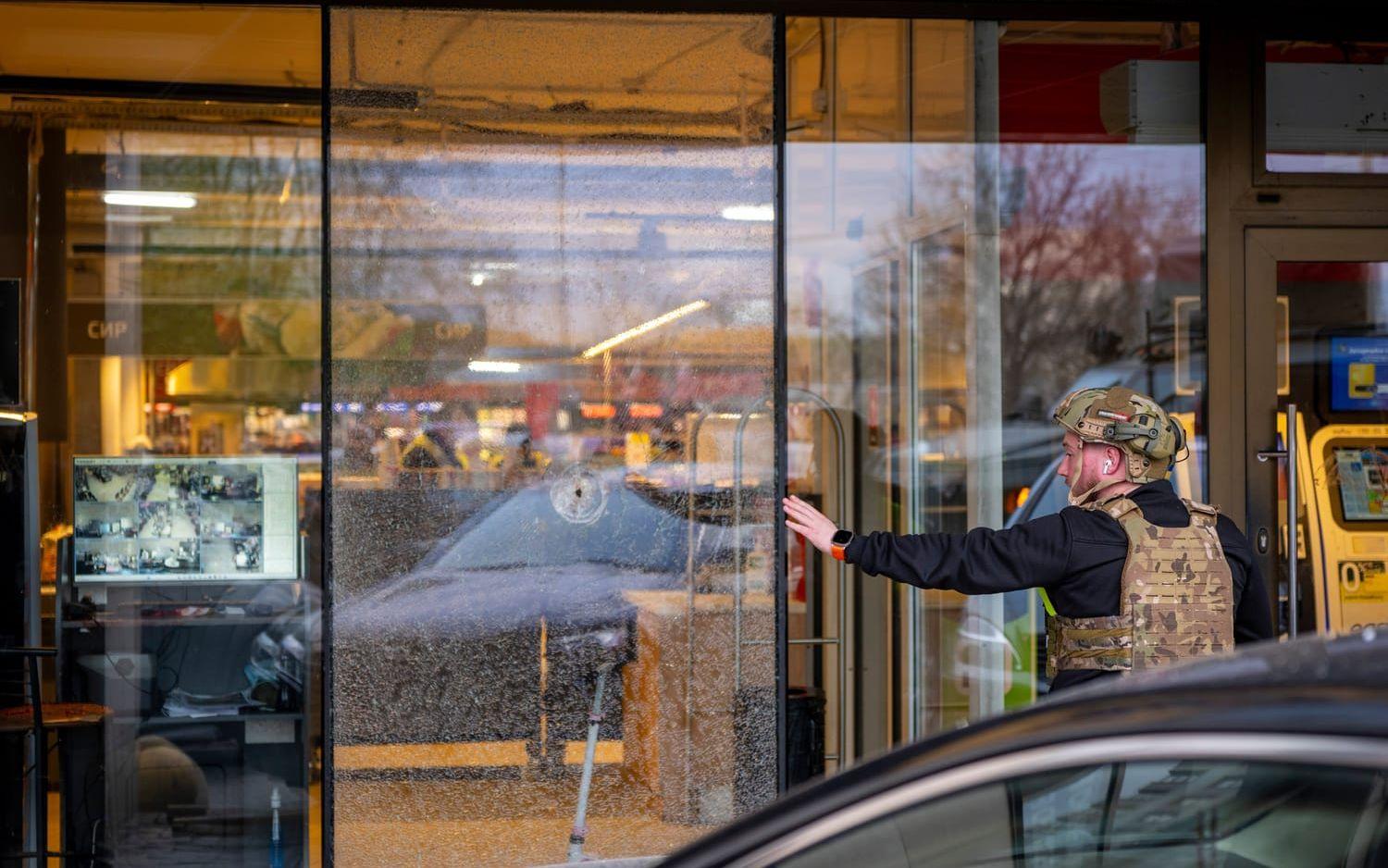 En polis vid den matvarubutik i Kiev där en man tog gisslan efter att ha skjutit ihjäl flera personer på lördagen.