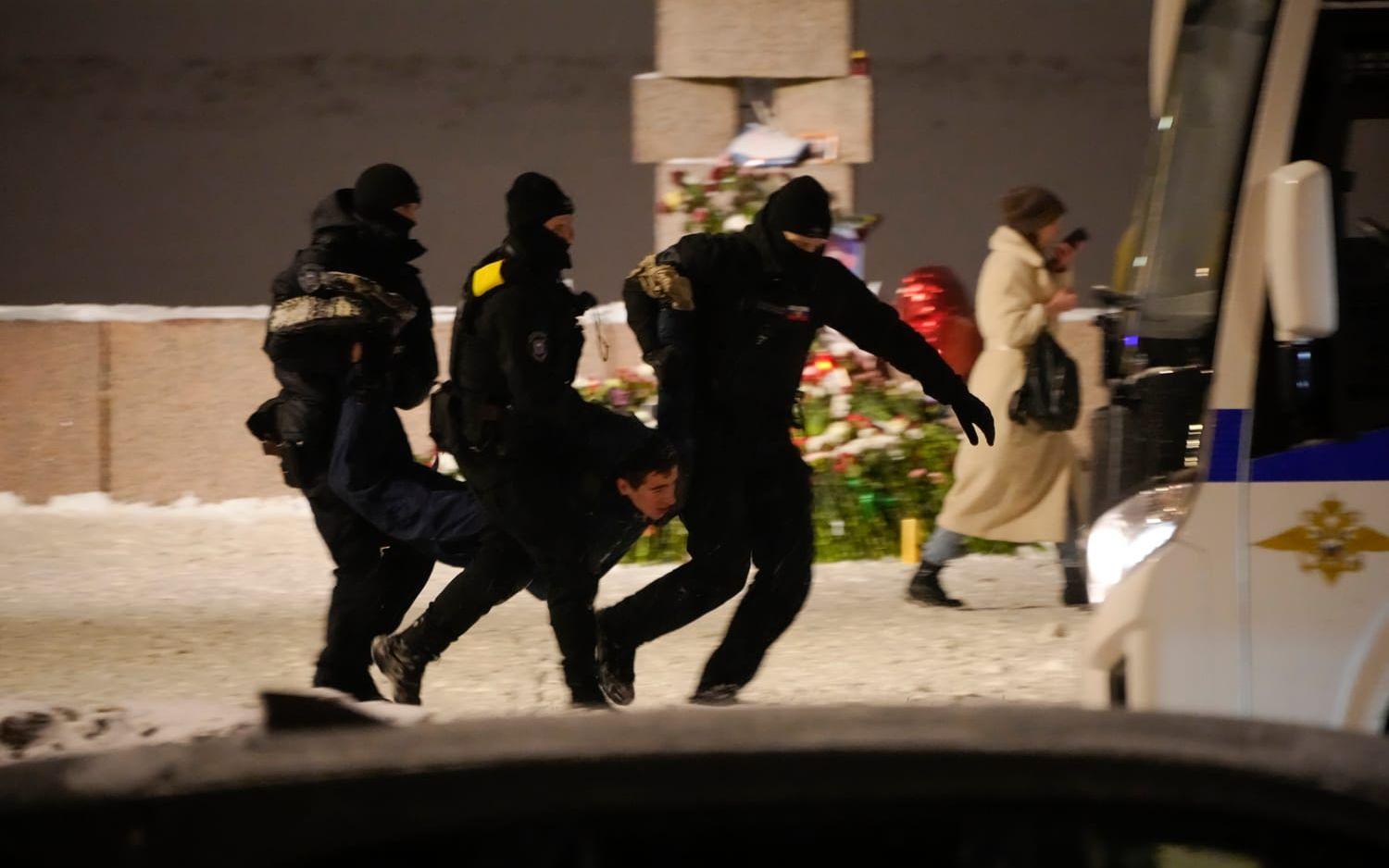 Polis i S:t Petersburg bär bort en man som lagt blommor vid ett monument för att hedra Aleksej Navalnyj. Bild från i fredags.