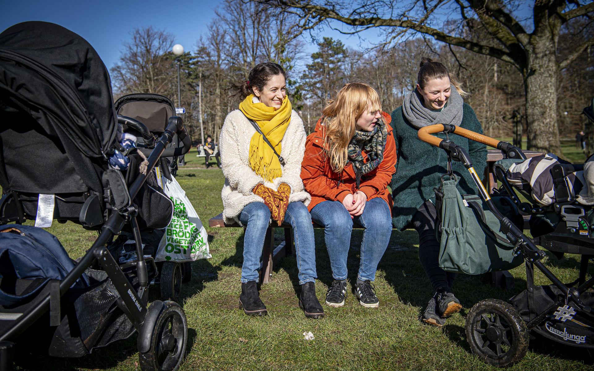 Vännerna Remina Kisimov, Emma Nordenberg och Hanna Söderquist tar ett paus i solen på en parkbänk i Slottsskogen innan de går vidare med barnen för att titta på djuren i parken.